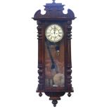 A late 19thC Vienna wall clock, the arched and moulded top on two column supports, with pendulum and