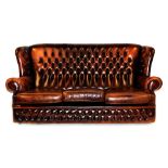 A brown leather Chesterfield style three seater sofa, with three drop in cushions and studded detail