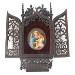 A late 19thC cased religious icon, the carved and pierced mahogany fret work case opening to reveal