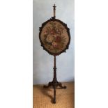 A Victorian mahogany pole screen, with shaped wool work panel of roses, 152cm high, 47cm wide, 45cm