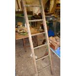 Thirteen round wooden ladders, and a set of double steps. (2)