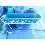 A modern wrought iron planter with plastic box.