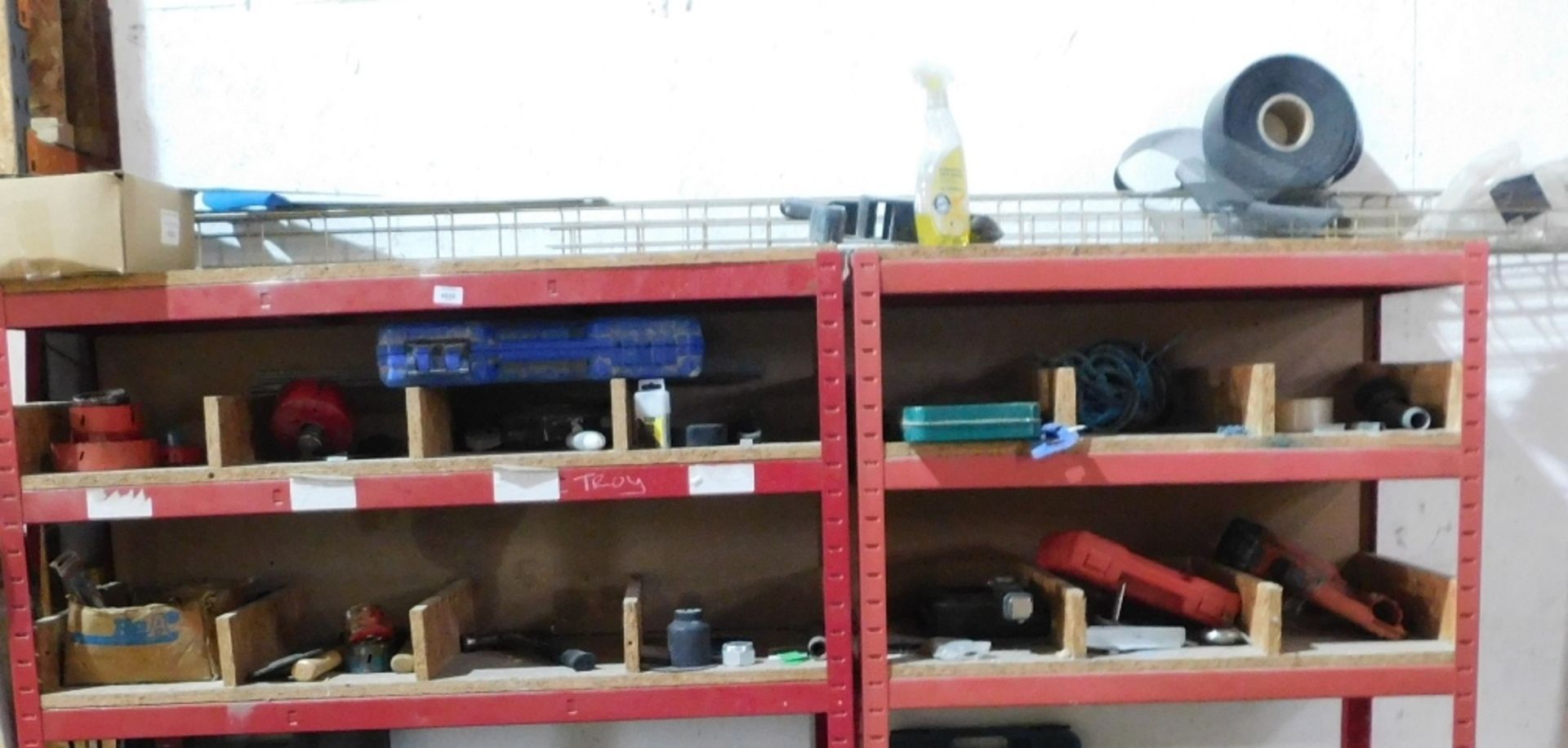 Two red steel part racks and including the residual contents, being various tools, staple guns, etc.
