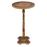 An early 20thC lacquered wood pedestal table, the circular dished top applied with figures in red an