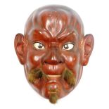 A Japanese red lacquer noh mask, of Okina, his facial hair applied with animal fur, 20cm high.