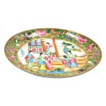 A 19thC Chinese Canton famille rose dish, decorated with figures in interior scene surrounded by a b