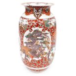 A Japanese Meiji period pottery vase, of cylindrical form with a flared rim, decorated with a reserv