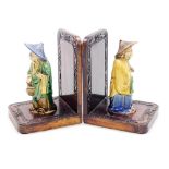 A pair of Chinese hardwood bookends, set with mudman figures and a carved floral border, 16cm high.