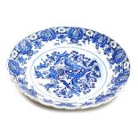 A 19thC Delft blue and white charger, with a waved border, the centre decorated with vase surrounded