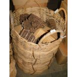A large wicker log basket, with four ring handles, 88cm high, and a variety of woven and heart shape