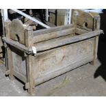 A Javanese hardwood chest, of rectangular form, with raised shaped sides and carved floral front pan