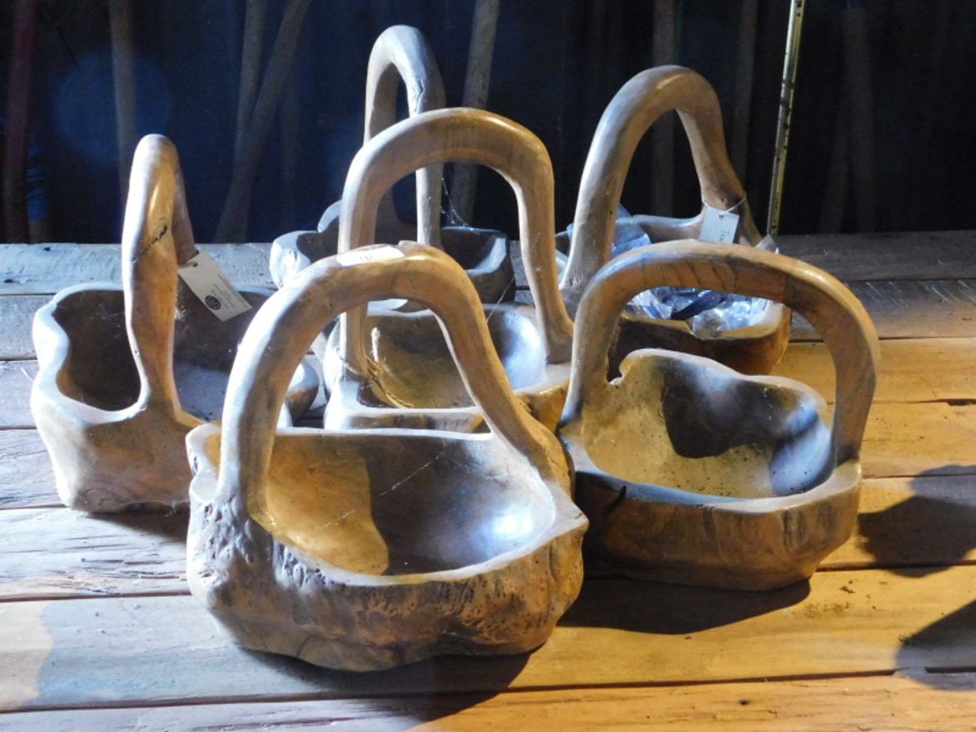 Six carved teak baskets, each approx 30cm high. Note: VAT is payable on the hammer price of this lot