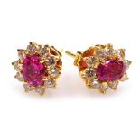 A pair of ruby and diamond cluster earrings, the central facet cut ruby of 6.1mm x 5.2mm surrounded