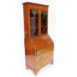 An Edwardian mahogany bureau bookcase, with satinwood cross banding, the outswept pediment with dent