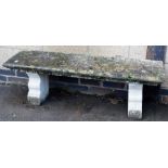 A composition garden bench, with a square top on two shaped supports, 43cm high, 133cm wide, 43cm de