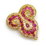 A ruby and diamond set brooch, of Eastern scroll shape set with twenty seven oval faceted rubies ran
