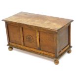 An early 20thC oak blanket chest, the front carved with a leaf pattern, raised on ball feet, 50.5cm