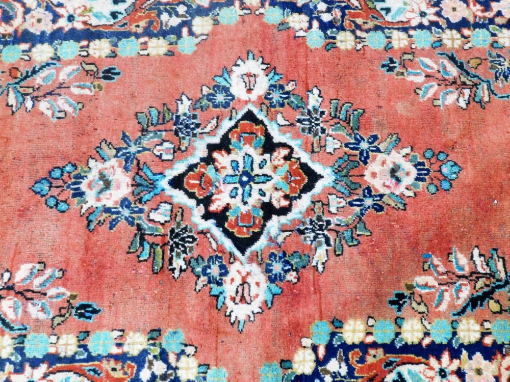 A Turkish red ground rug, decorated with a central floral medallion, the field with further flowers - Image 2 of 3