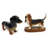 A Beswick matt pottery figure of a Basset Hound, raised on an oval wooden base, and a gloss figure o