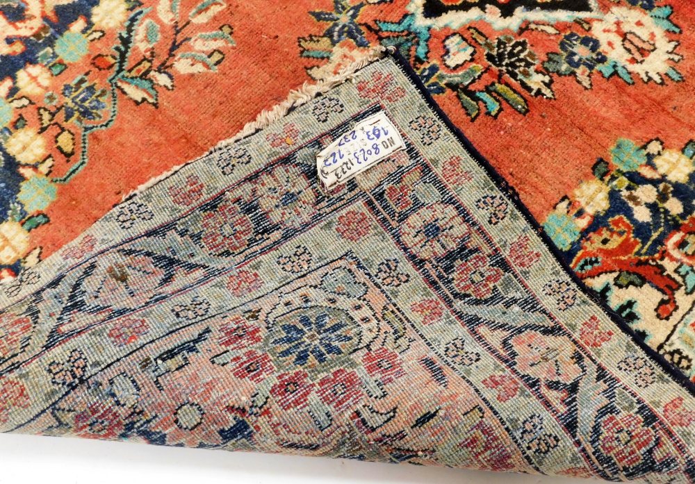 A Turkish red ground rug, decorated with a central floral medallion, the field with further flowers - Image 3 of 3