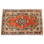 A Turkish red ground rug, decorated with a central floral medallion, the field with further flowers