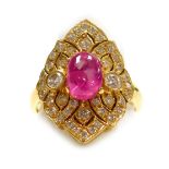 A cabachon ruby and diamond lozenge shaped dress ring, a central ruby of 8.1mm x 5.4mm, surrounded b