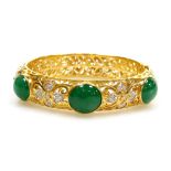 An ornate jade and diamond set hinged bangle, three cabachon jade stones of 11.3mm x 9.1mm approx ea