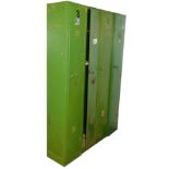 Four green metal lockers, the hinged doors enclosing an arrangement of shelves, each 183cm high, 31c