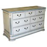 A cream and pale blue painted pine chest of three short over four long drawers, raised on a plinth b