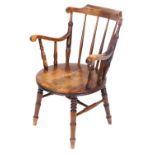 A Victorian oak and beech carver chair, with a curved crest rail, spindle back, circular solid seat