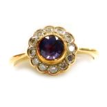 A diamond and sapphire set dress ring, the round central stone of 4mm diameter, surrounded by twelve