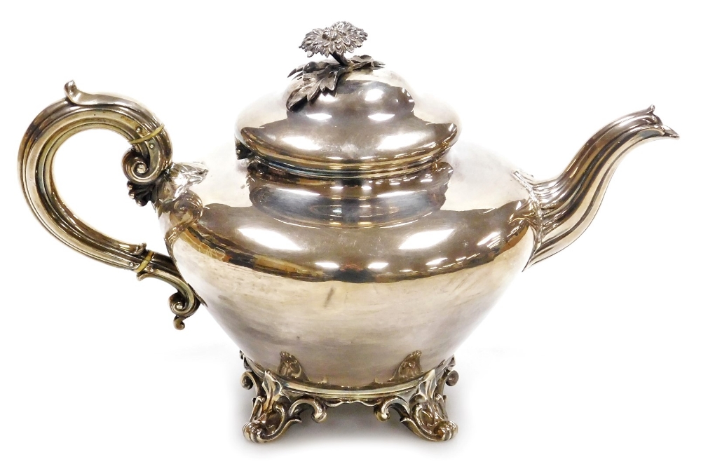 A Victorian silver melon shaped teapot, of plain form, with a floral finial and scroll handle, raise