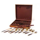 A late 20thC brass and teak canteen of cutlery, cased.