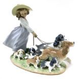 A Lladro Privilege Collection porcelain figure group of a girl walking two dogs, with puppies along