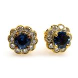 A pair of sapphire and diamond cluster earrings, the central oval faceted sapphire of 5.2mm x 4.5mm