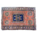 A Turkish red ground rug, decorated with five framed floral motifs, within repeating geometric borde