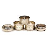 Three George V silver napkin rings, with engine turned decoration, Birmingham 1923, and two further