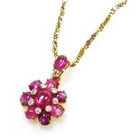 A floral pendant on chain, set with cabachon rutile filled rubies and tiny diamonds on a cabachon ru