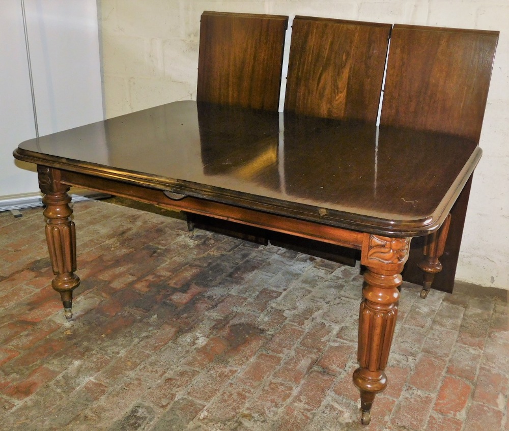 A Victorian style mahogany draw leaf dining table, with three additional leaves, raised on turned an