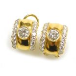 A pair of diamond set clip and post earrings, the central diamonds of 5.5mm diameter each flanked by
