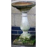 A composition bird bath, with circular top on a baluster shaped column, above a square base, 67cm hi