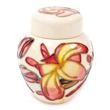 A Moorcroft Frangipani pattern pottery jar and cover, printed marks and signed to underside, 11cm hi