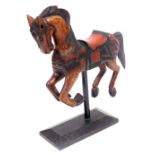 A carved and painted wooden model of a galloping horse, raised on a rectangular stand, 88cm high.