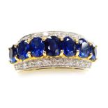 A sapphire and diamond set dress ring, a central row of sapphires of 5mm x 3.5mm average faceted sto