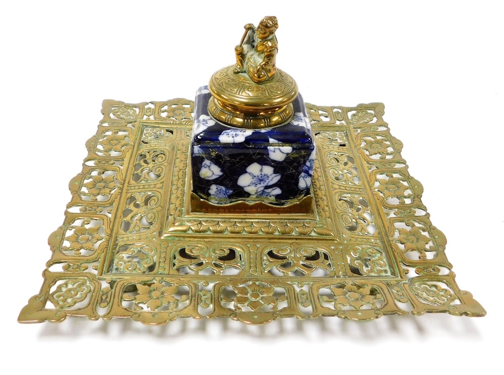 A Victorian brass and porcelain inkwell, the Coalport inkwell with a hinged lid surmounted by an Ori