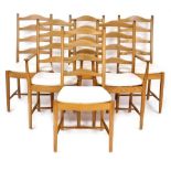 A set of six Ercol elm ladder back dining chairs, with slatted and loose cushion seats, raised on tu