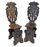A pair of early 19thC Italian oak Sgabello hall chairs, with foliate carved crest rails, the back ca