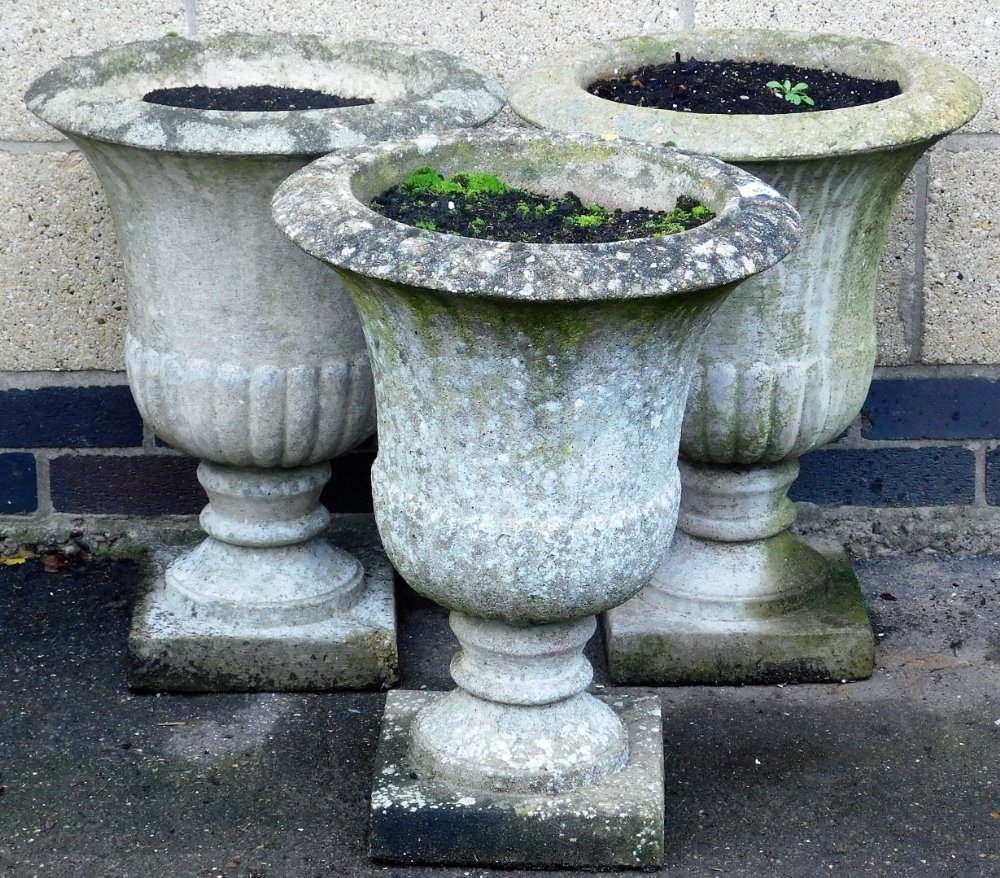Three composition garden planters, of urn form, on a square base, 53cm high.