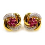 A pair of ruby and diamond set large stud earrings, flower and ribbon form, butterfly backs, the cen