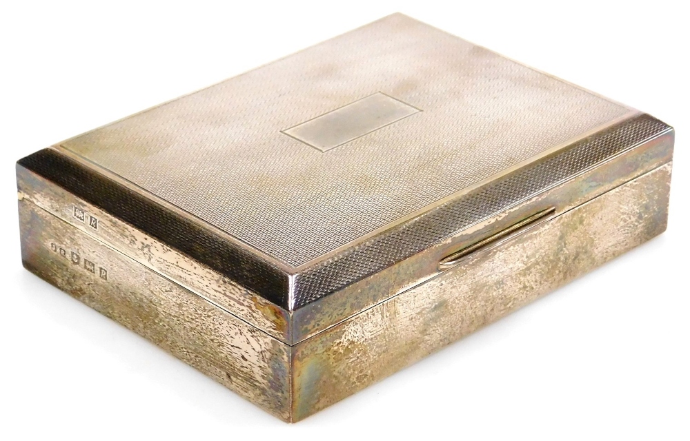 A Elizabeth II silver cigarette box, with engine turned decoration, vacant shield reserve, Birmingha
